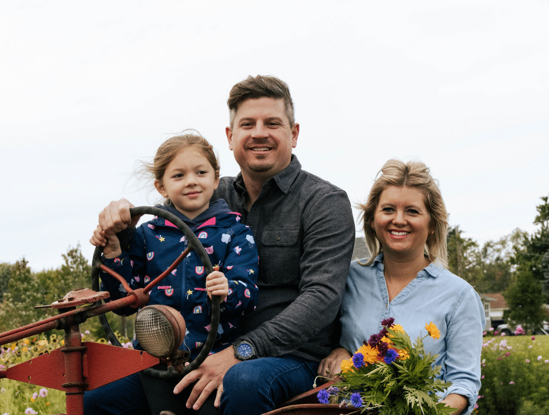 Happy family on vintage tractor enjoying a sunny countryside day together