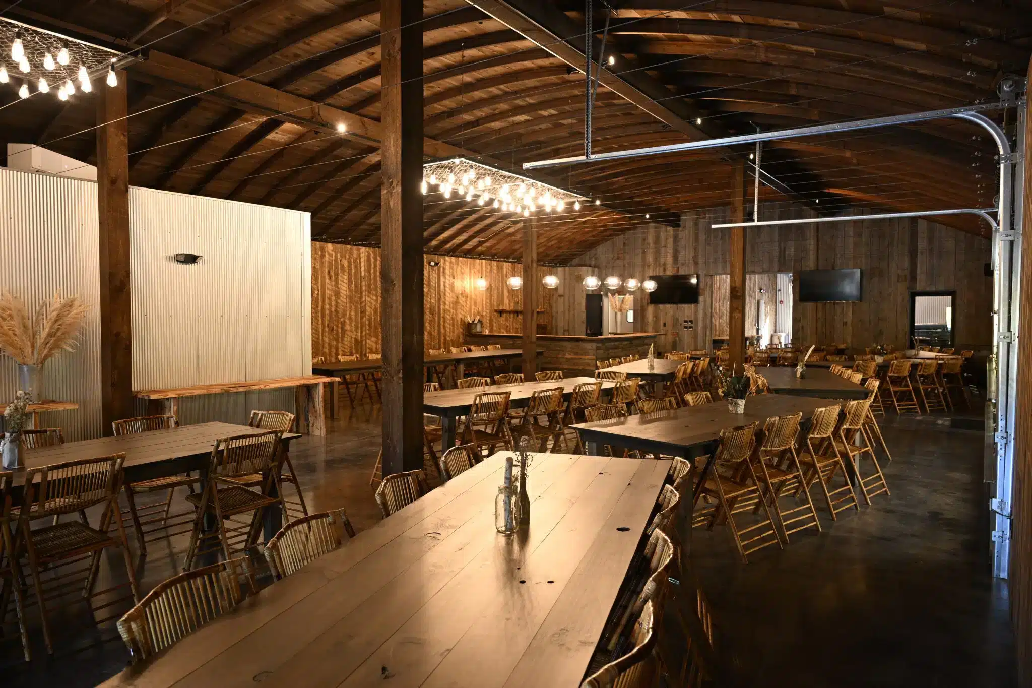 Rustic barn-style event space in Madison, Ohio with wooden tables and warm ambient lighting.