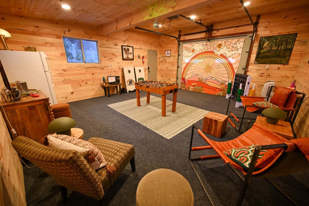 Rustic cabin recreation room with foosball table, warm lighting, and cozy seating for relaxation.